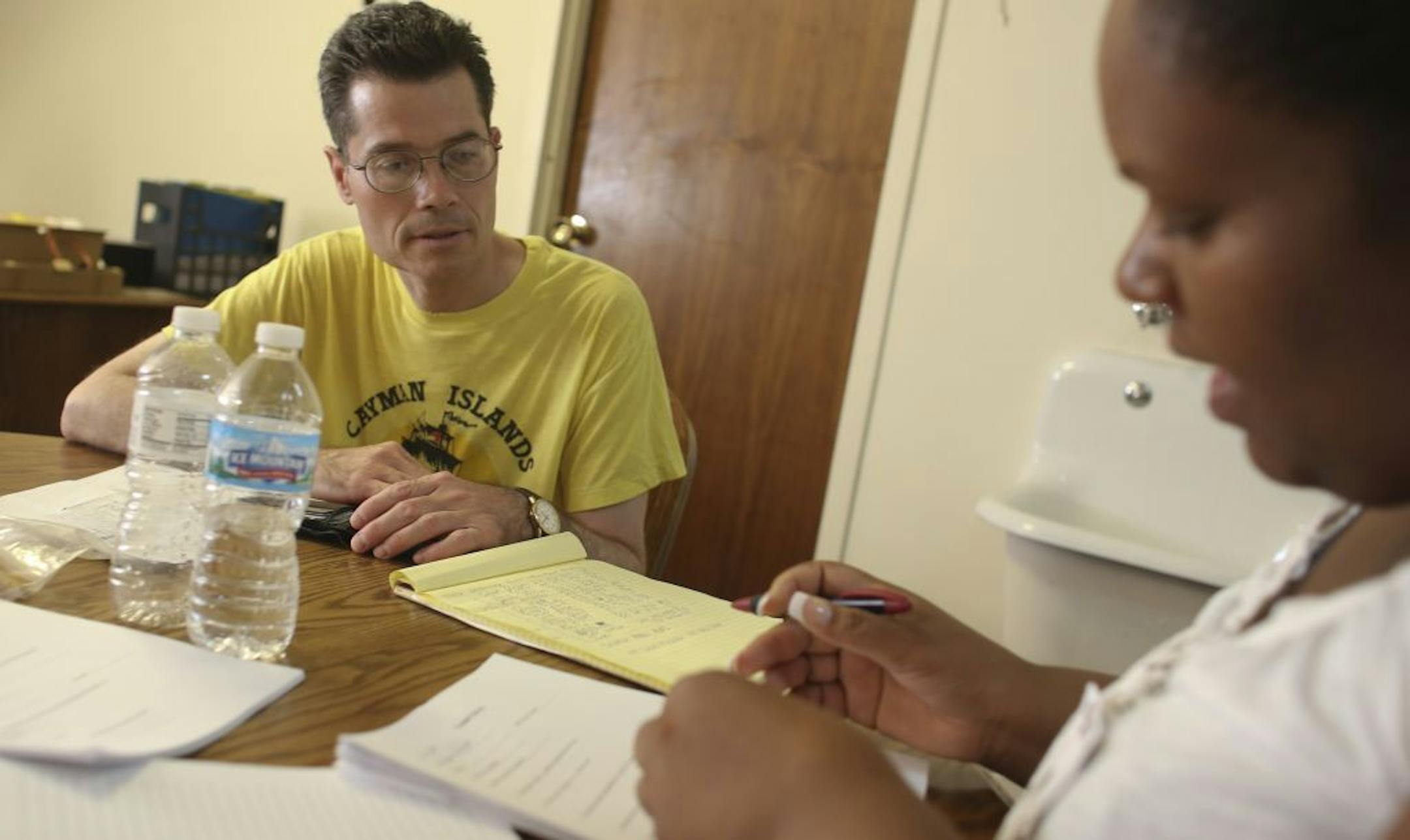 Advocate Helen Flowers discussed relocation information with John Wright. He said that he loved his "hole- in the wall" apartment because it was cheap and close to his church, friends and the bus line.