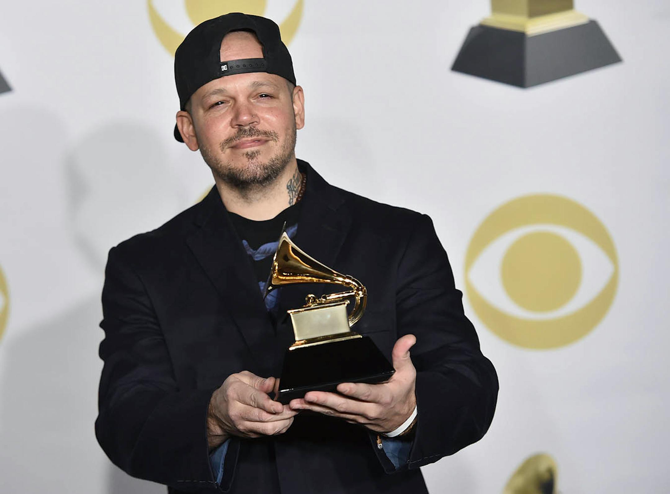 Residente poses in the press room with the best Latin rock, urban or alternative album award for "Residente" at the 60th annual Grammy Awards at Madison Square Garden on Sunday, Jan. 28, 2018, in New York. (Photo by Charles Sykes/Invision/AP)