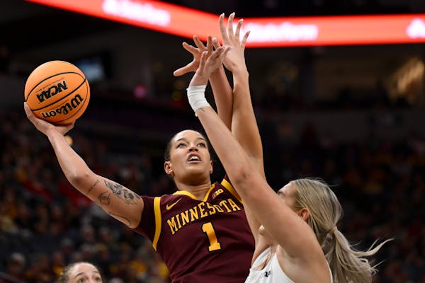 Gophers forward Ayianna Johnson drives toward the basket to attempt a layup against Michigan forward Chyra Evans in the first half.