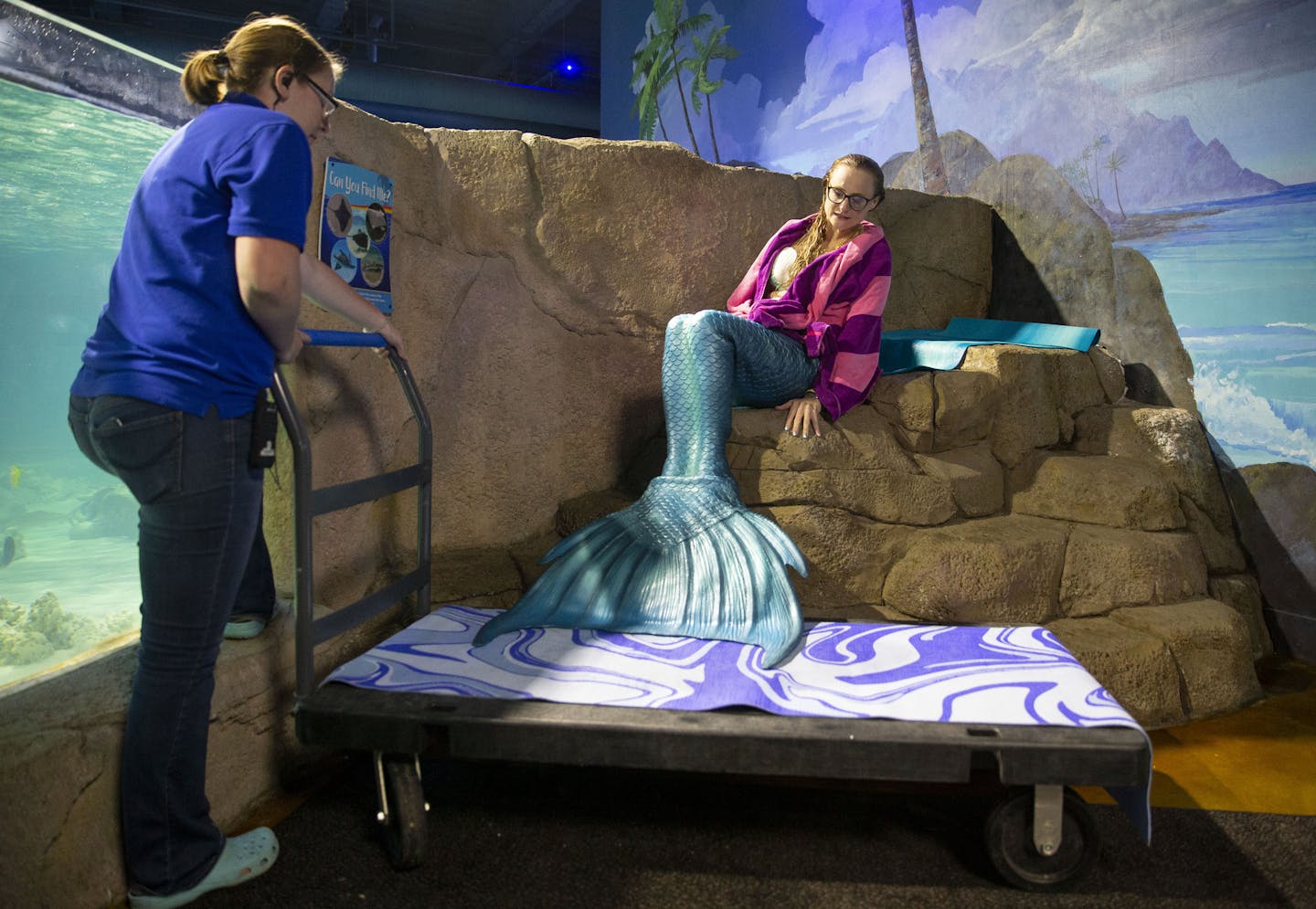 Lindsey Stupica is helped onto a flatbed cart after swimming in a saltwater tank. She has to be carted from place to place in SeaQuest because she can't use her legs while in costume.