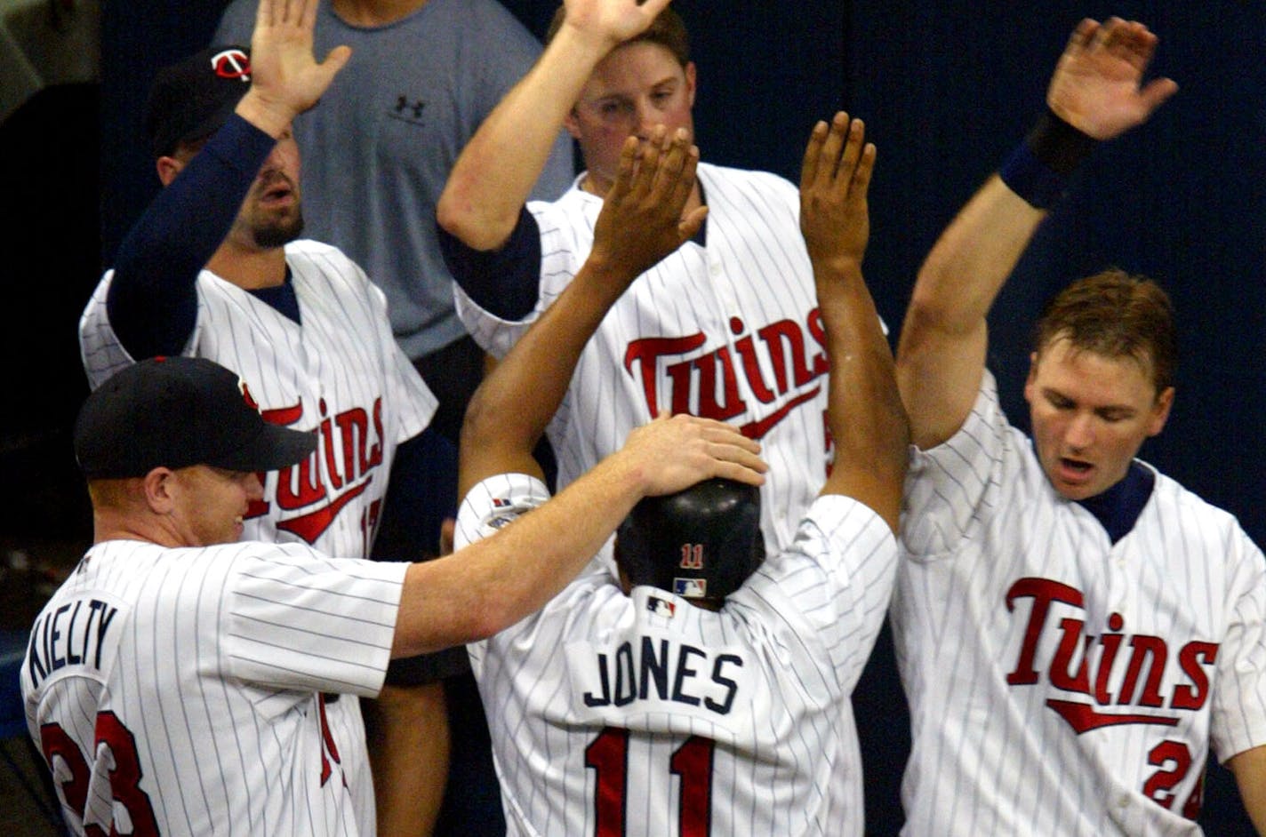 Jacque Jones (11) got a little recognition from his teammates after scoring in Game 4 of the 2002 American League Division Series against the Oakland Athletics.