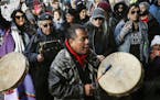 A protestor leads a Native American prayer with a traditional drum outside the Catholic Diocese of Covington Tuesday, Jan. 22, 2019, in Covington, Ky.