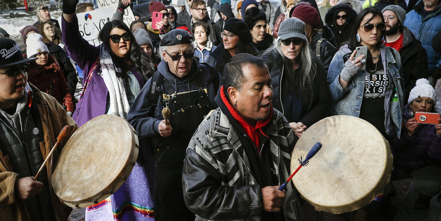 A protestor leads a Native American prayer with a traditional drum outside the Catholic Diocese of Covington Tuesday, Jan. 22, 2019, in Covington, Ky. The diocese in Kentucky has apologized after videos emerged showing students from Covington Catholic High School mocking Native Americans outside the Lincoln Memorial on Friday after a rally in Washington. (AP Photo/John Minchillo)