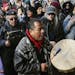 A protestor leads a Native American prayer with a traditional drum outside the Catholic Diocese of Covington Tuesday, Jan. 22, 2019, in Covington, Ky.