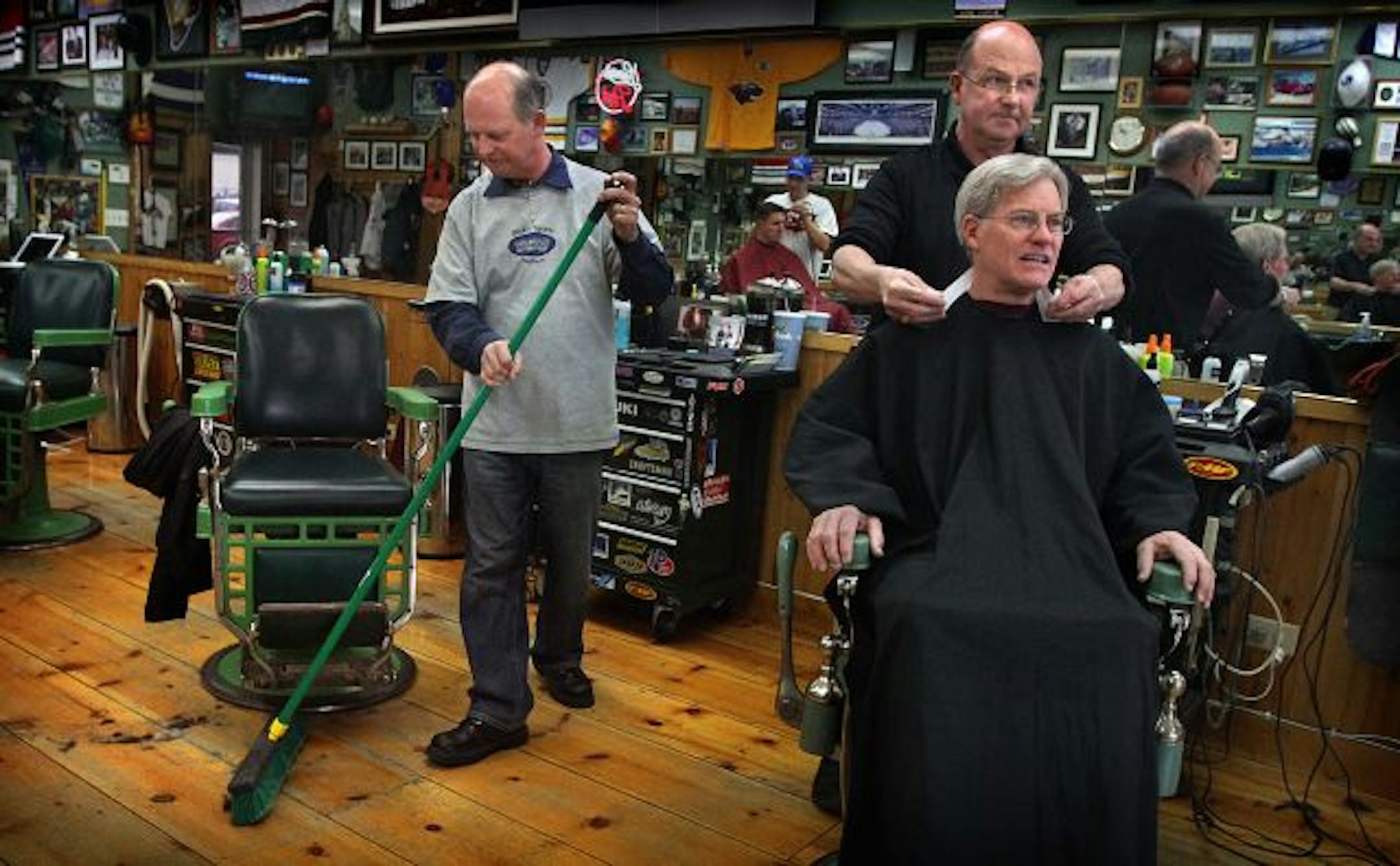 Dick Kramer (right, with customer Scott Reeves), owner of Dick's Sports Barbers in Edina, has worked side-by-side with fellow barber Gene Tuftin.