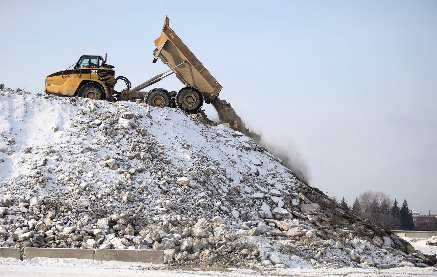 The massive Ford site in Highland Park, which occupies 144 acres including the Highland Little League Park, is now clear of buildings with pollution cleanup continuing and the remaining concrete foundations and slabs should be gone by mid-summer. The property is expected to go on the market by the end of 2015. Here, a truck dumps a load of concrete debris onto a pile that is eventually crushed into gravel for fill Wednesday, Jan. 14, 2015, in St. Paul, MN.](DAVID JOLES/STARTRIBUNE)djoles@startri