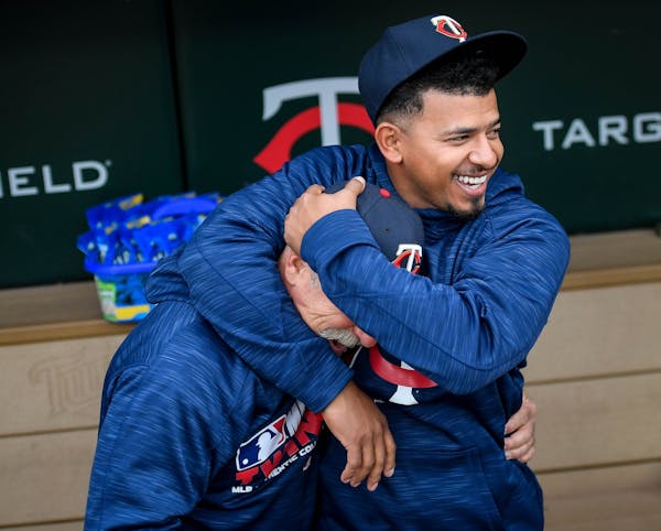 Minnesota Twins third baseman Eduardo Escobar (5) put conditioning coach Perry Castellano in a head lock as they joked around before the start of Tues