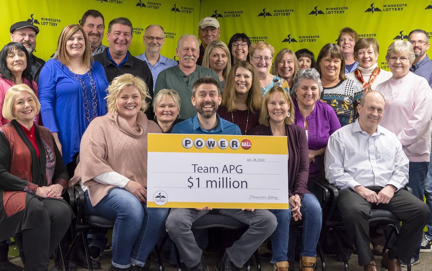 This group of coworkers is splitting a $1 million pre-tax payout from Saturday's Powerball drawing. Holding the placard was Dustin Uran, who buys lottery tickets on behalf of the group. Credit: Minnesota State Lottery