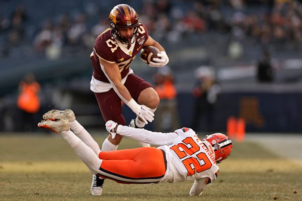 Minnesota running back Bryce Williams attempts to avoid Syracuse defensive back Quan Peterson during the first half of the Pinstripe Bowl NCAA college