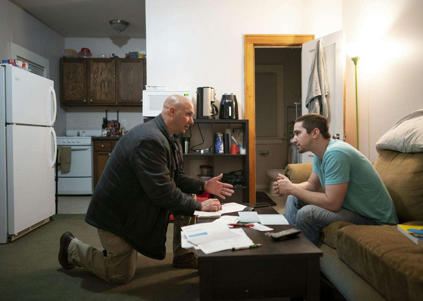 Agent Rick Defiel, left, talked with Daniel, a former inmate on supervised release, during a surprise evening visit.