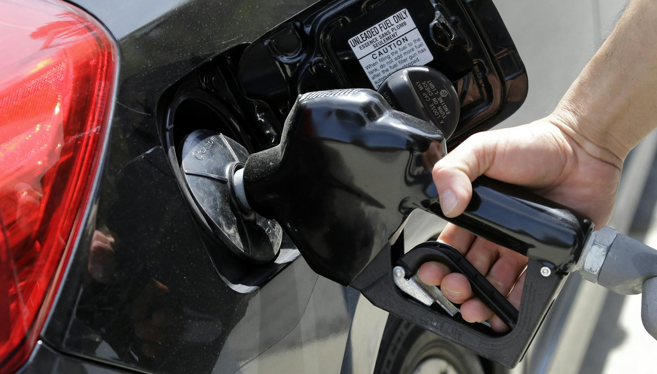 FILE - In this May 8, 2015, file photo, gas station attendant Carlos Macar pumps gas in Andover, Mass. Oil prices have plummeted over the last year, a result of high global supplies and weaker demand than expected. U.S. drivers are paying less than $2 a gallon on average for the first time since the Great Recession. (AP Photo/Elise Amendola, File)
