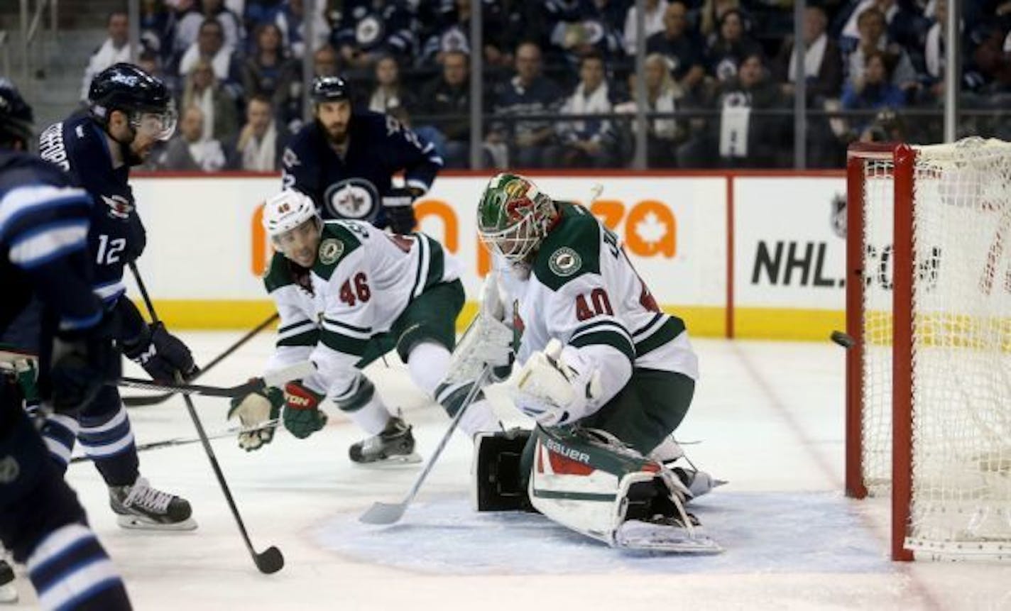 Winnipeg Jets' Drew Stafford (12) scores on Minnesota Wild goaltender Devan Dubnyk (40) during second period NHL hockey action in Winnipeg, Sunday, Oct. 25, 2015. (Trevor Hagan/The Canadian Press via AP)