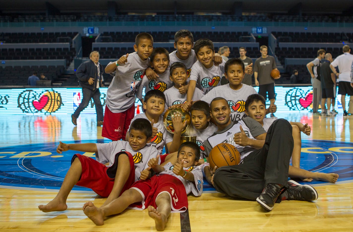 San Antonio Spurs guard, Patty Mills, right, poses for photos with children belonging to an indigenous Triqui basketball team from Oaxaca state during a practice session in Mexico City, Tuesday Dec. 3, 2013. The children, who recently won an international competition in Argentina, practiced with the NBA's players. Minnesota Timberwolves and San Antonio Spurs are in Mexico to play on Wednesday Dec. 4. (AP Photo)