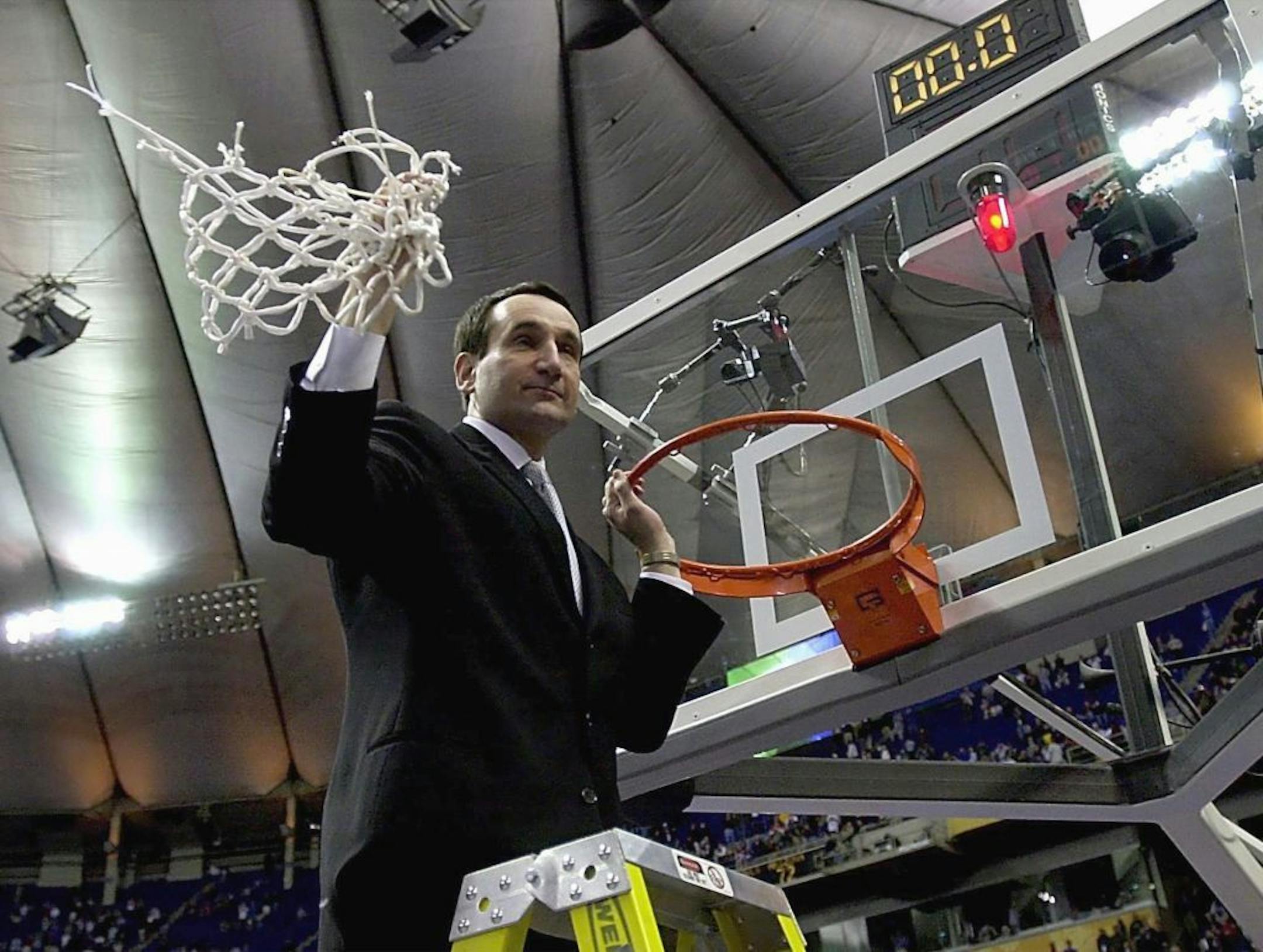 Duke head coach Mike Krzyzewski cuts down the net after the Blue Devils' 82-72 victory against Arizona to win the NCAA National Championship in 2001.