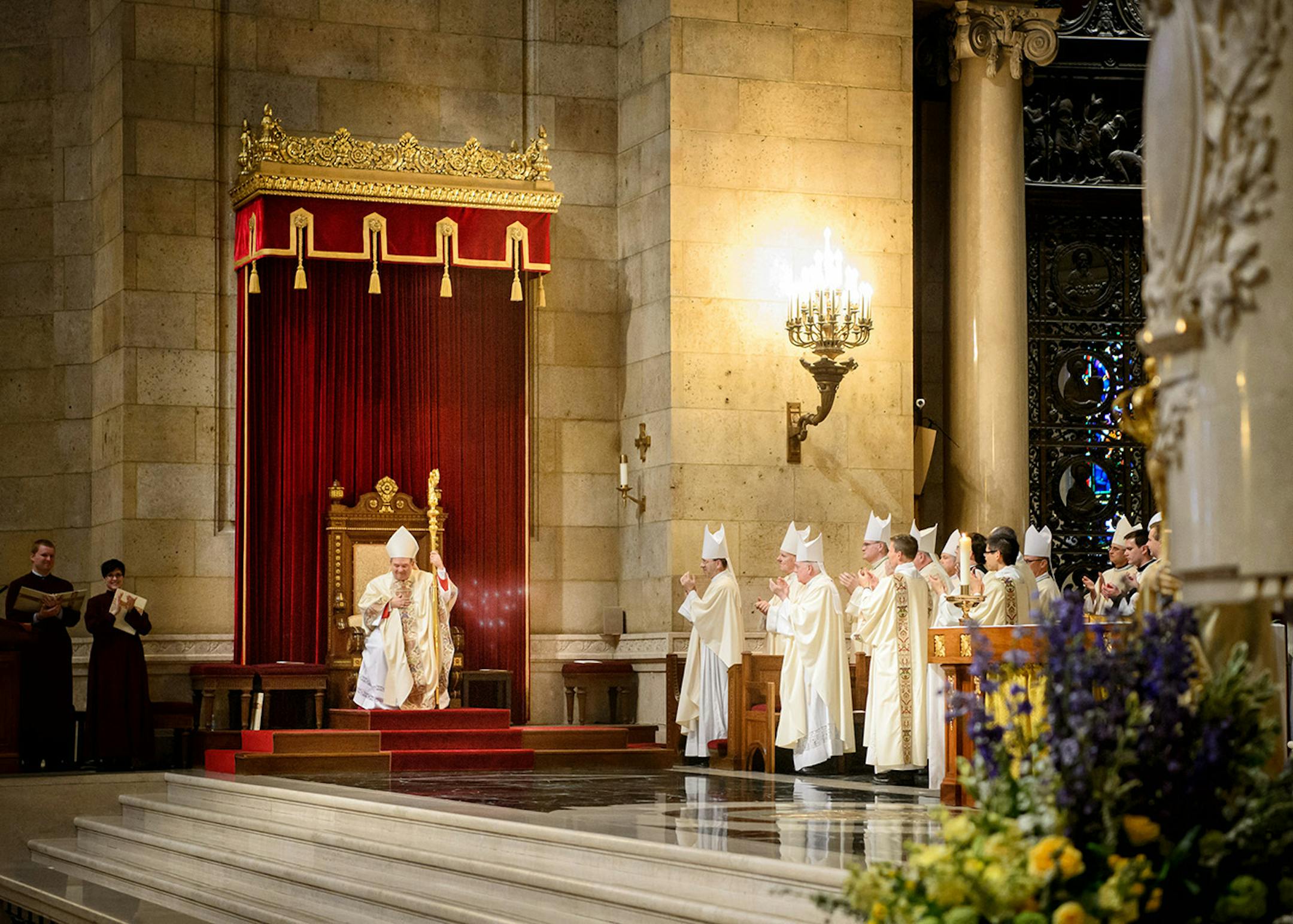 For the first time Archbishop Bernard Hebda took his seat at the cathedra or bishops throne on the altar and acknowledged the sustained applause from the crowd.