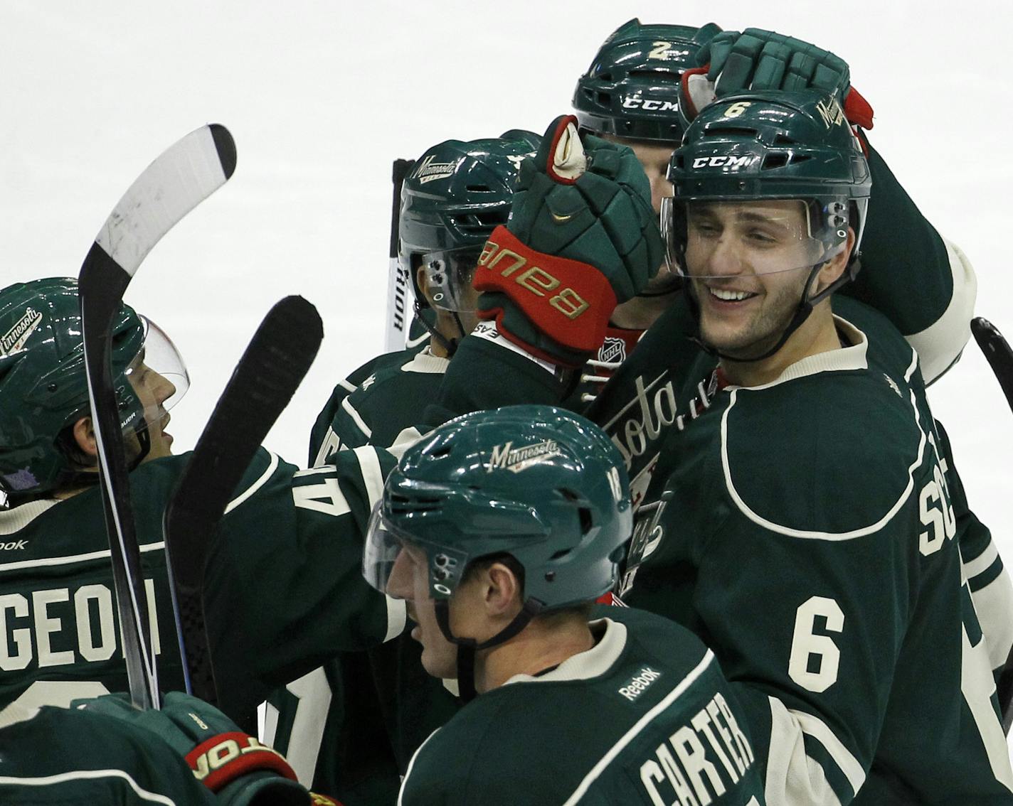 Minnesota Wild defenseman Marco Scandella (6) is congratulated by teammates after scoring the game-winning goal on Winnipeg Jets goalie Michael Hutchinson during overtime of an NHL hockey game in St. Paul, Minn., Sunday, Nov. 16, 2014. The Wild won 4-3 in overtime. (AP Photo/Ann Heisenfelt)