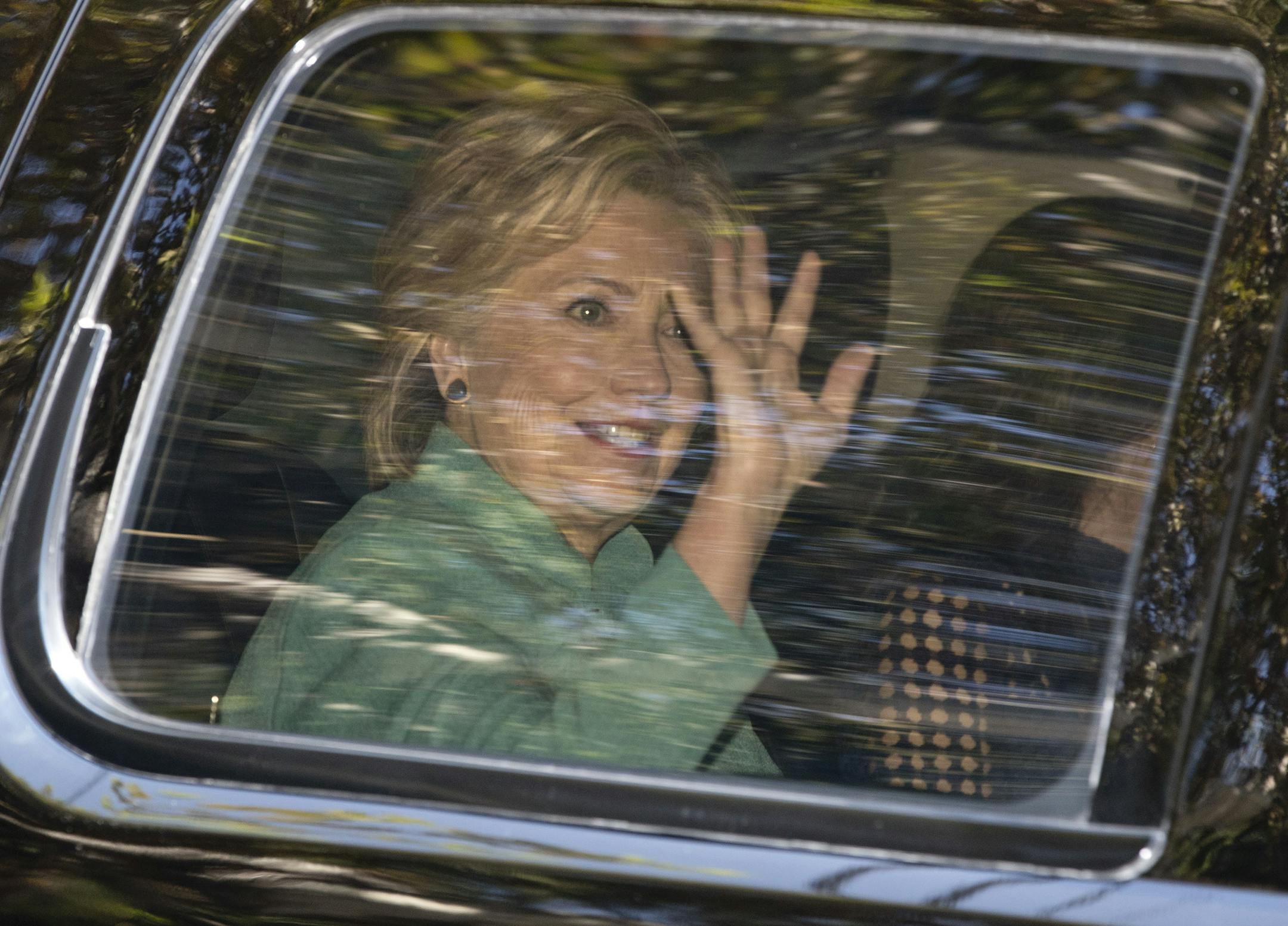 Democratic presidential candidate Hillary Clinton waves from her motorcade vehicle as she arrives for a fundraiser at the home Justin Timberlake and Jessica Biel in Los Angeles, Tuesday, Aug. 23, 2016. (AP Photo/Carolyn Kaster)