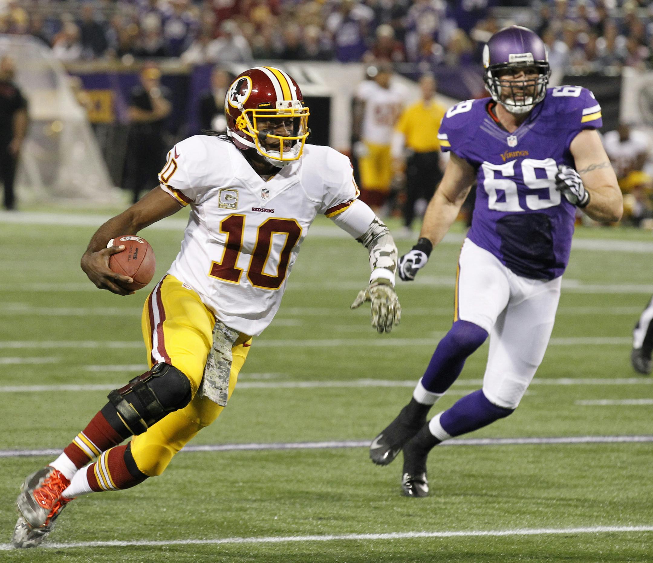 Redskins quarterback Robert Griffin III ran from Vikings defensive end Jared Allen during the first half.
