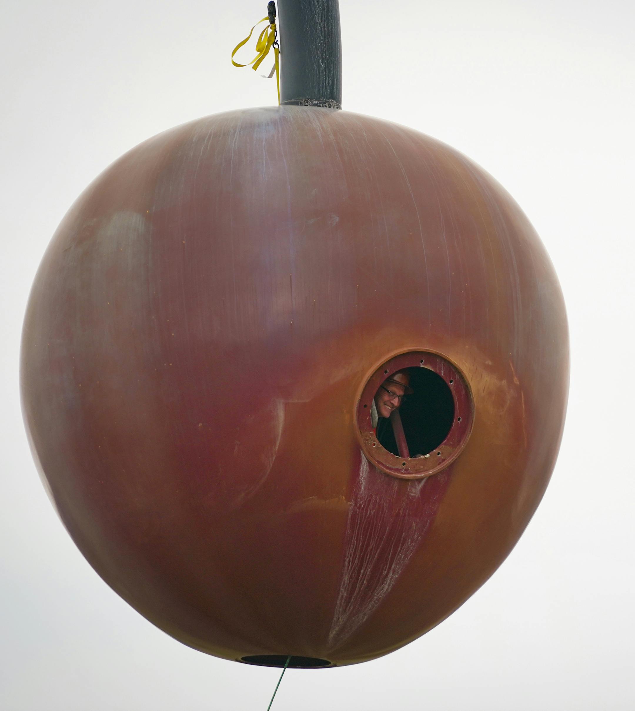 The 1200 pound aluminum cherry ball is unbolted, lifted, and separated from the Spoonbridge base it sits atop at the Sculpture Garden.