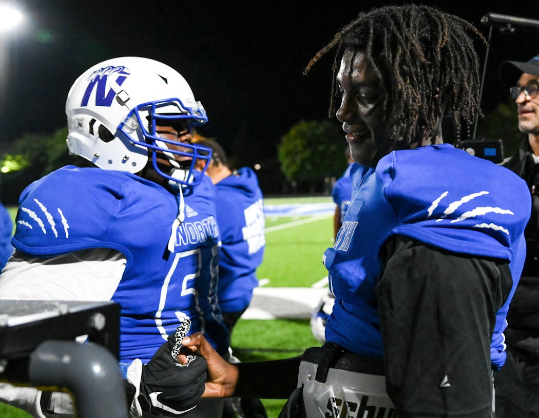 Minneapolis North High quarterback Deshaun Hill, right, shook a teammate’s hand after winning a game against SMB Wolfpack in September 2021.