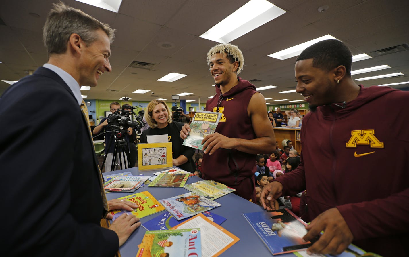 Gophers basketball players Jarvis Johnson, right, and Jarvis Omersa, picked out the books they were going to read to third graders at Pillsbury Elementary School in Minneapolis. Looking on are Minneapolis Public Schools Superintendent Ed Graff and Pillsbury principal Jessica Skowronek.