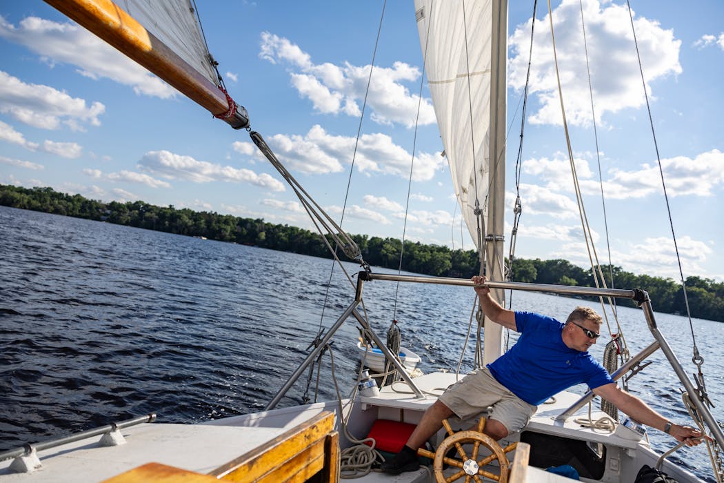 John Lown steers the Dar-Ja while adjusting a sail on the St. Croix River near Hudson, Wis. 