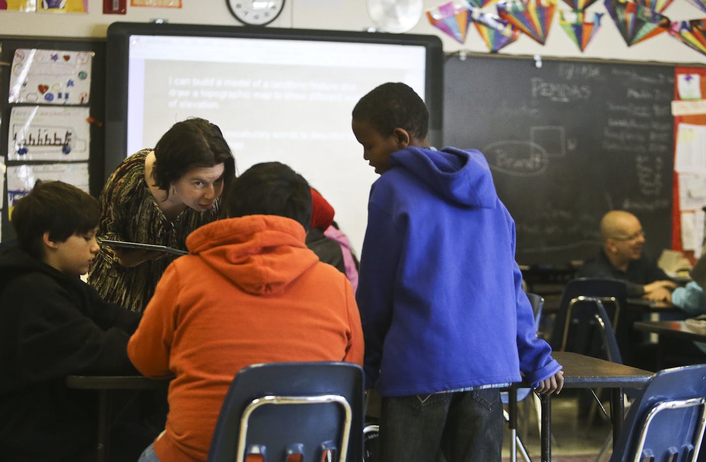 At Pillsbury Elementary School it is becoming more common for teachers and paras to team-teach in classrooms so that often more than one adult is in classrooms -- a model the district plans to put in place in some of its schools. Here, Mandy Franz, second from left, and 5th grade teacher Joel Lurvey, right, team up on a science lesson.