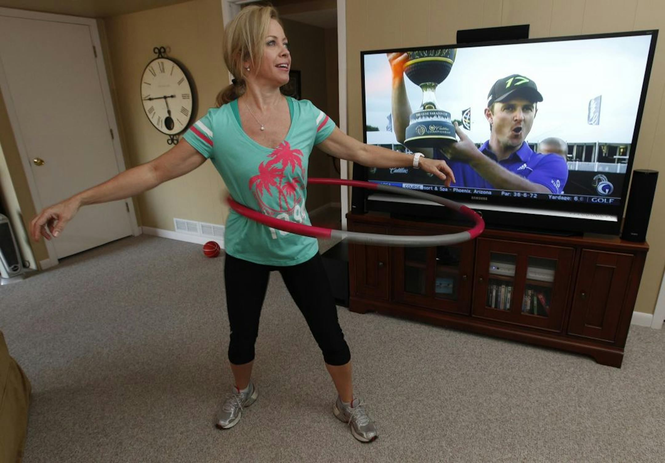 Kathleen Cancilla enjoys watching TV while she hula-hoops.