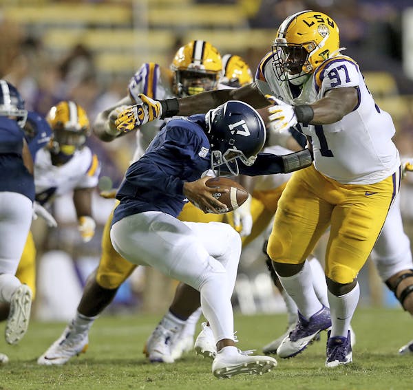 Georgia Southern quarterback Justin Tomlin (17) is wrapped up by LSU defensive end Glen Logan (97) in the third quarter of an NCAA college football ga