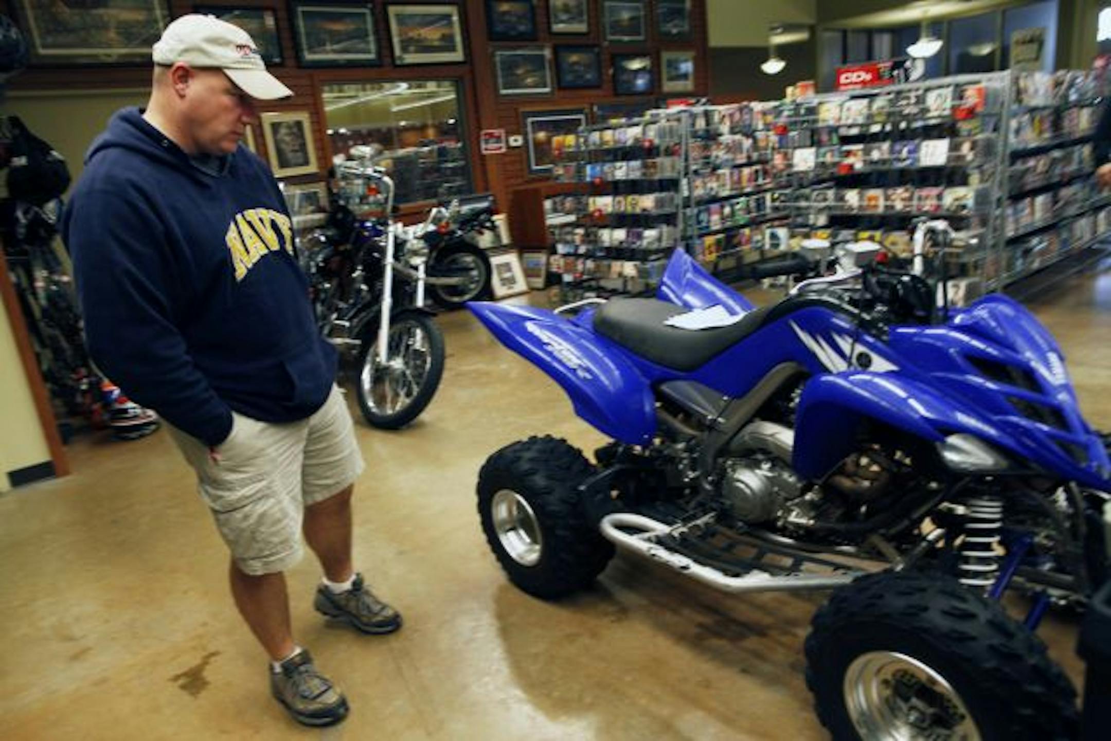 Shawn Mathison of Savage checked out an ATV at the Pawn America store in Burnsville, where licensing fees have been slashed by the City Council.