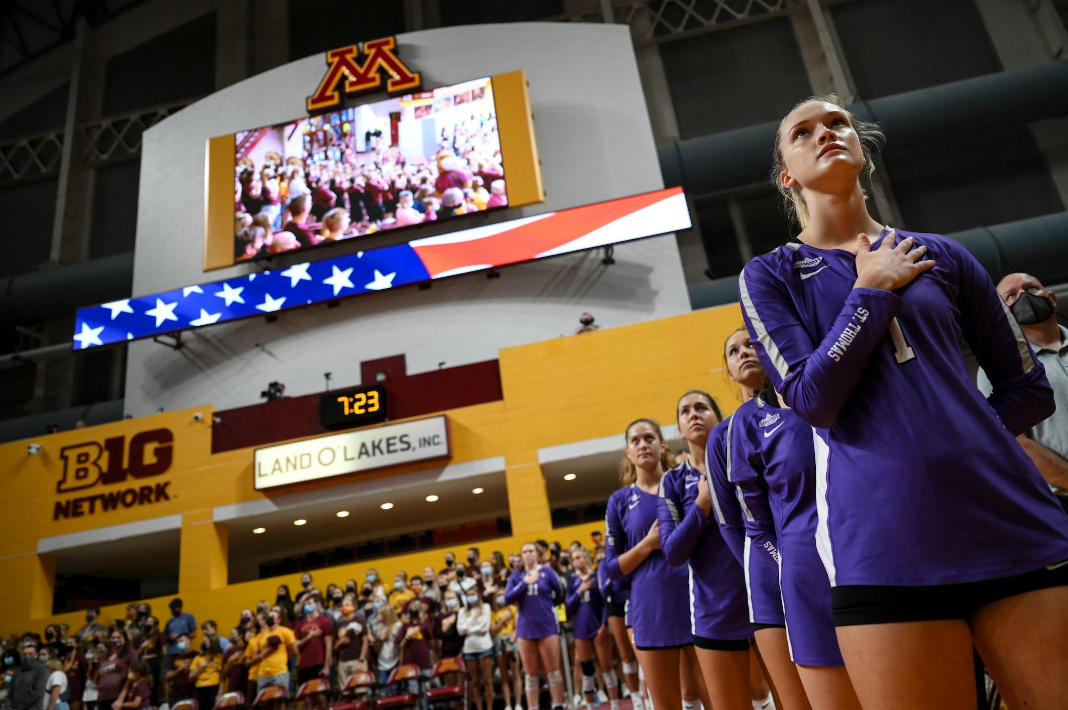 The St. Thomas Tommies, including middle blocker Ellie Dammann (1), from right, stood for the national anthem before Thursday night's match against the University of Minnesota Gophers.