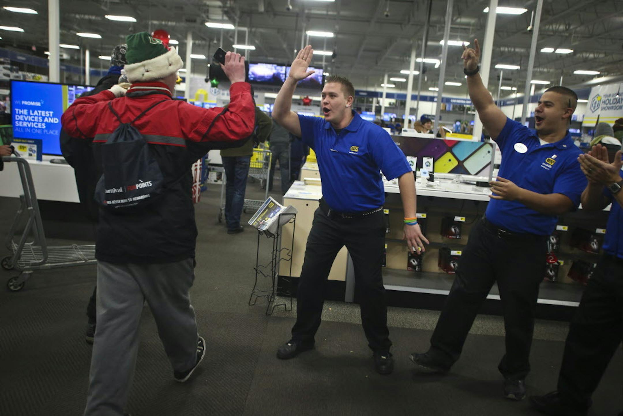 Best Buy employee Billy Wilebski, left, gave a high-five to the first people in the doors at 6 p.m. for Black Friday shopping at Best Buy on Thursday, November 28, 2013 in Roseville, Minn. ] RENEE JONES SCHNEIDER • reneejones@startribune.com