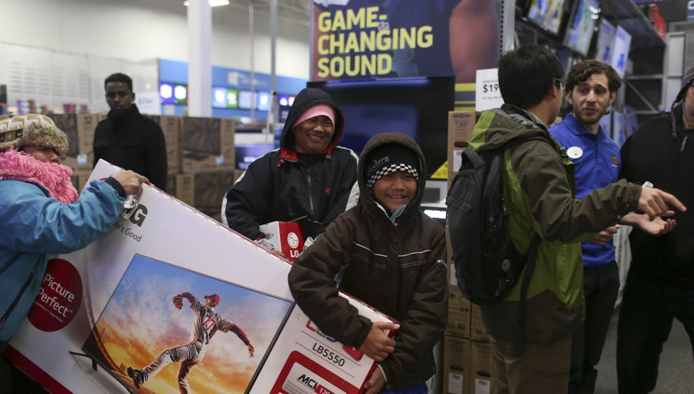 A family carried two flat screen televisions towards checkout shortly after the Roseville Best Buy store opened Thursday evening. ] JEFF WHEELER &#x201a;&#xc4;&#xa2; jeff.wheeler@startribune.com Best Buy stores opened for Black Friday shopping at 5 p.m. Thanksgiving evening, November 27, 2014. CEO Hubert Joly was at the Best Buy store in Roseville when it opened and greeted customers as they rushed in.