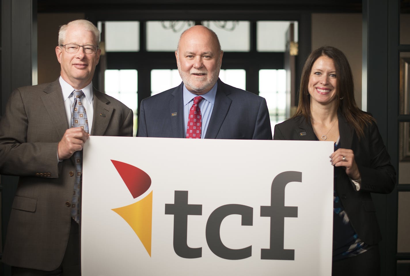 From left, TCF marketing executive Geoff Thomas, vice chairman Craig Dahl and marketing executive Jennifer Rohling held up a poster with the company's new branding at the TCF Bank headquarters in Wayzata Wednesday afternoon. ] Aaron Lavinsky &#x2022; aaron.lavinsky@startribune.com TCF Vice Chairman Craig Dahl and marketing executives Geoff Thomas and Jennifer Rohling were photographed at the TCF Bank Headquarters in Wayzata on Wednesday, May 20, 2015. TCF Bank will be launching a new look and ma