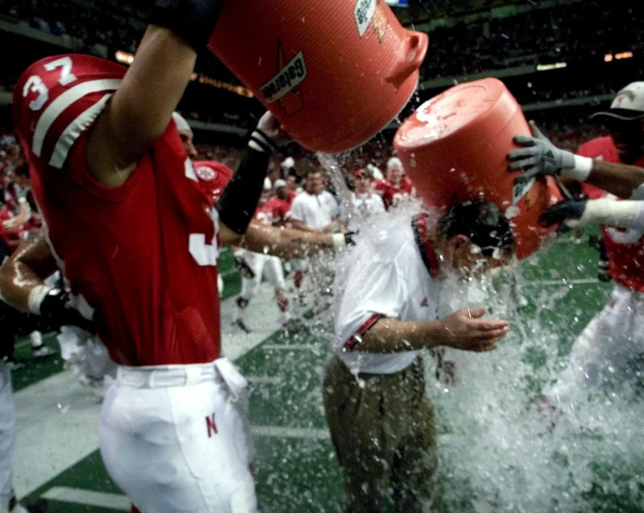 Nebraska's Tony Ortiz (37) and Mark Vesral (9) dunk coach Frank Solich with water after the Huskers beat Texas 22-6 in the Big 12 Championship game in San Antonio, Texas, Dec. 4, 1999. (AP Photo/Eric Gay) ORG XMIT: SAD108