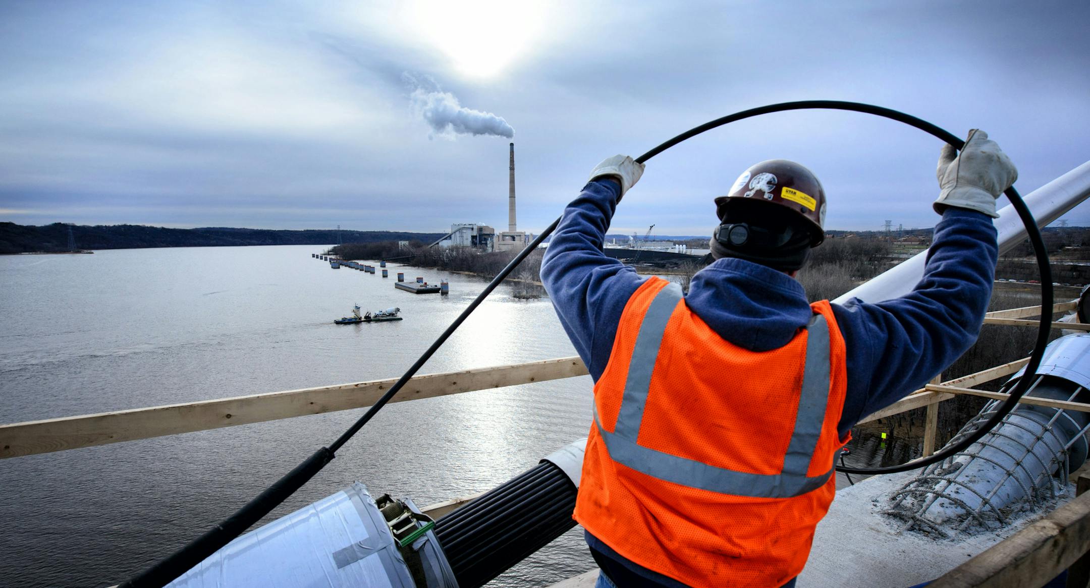 A worker pulled suspension cable to hold the massive St. Croix Crossing bridge. ] GLEN STUBBE * gstubbe@startribune.com Friday, November 20, 2015 Construction of the massive St. Croix Crossing bridge project in Stillwater, MN will be 60 percent finished when winter hits, but questions remain about a new completion date.