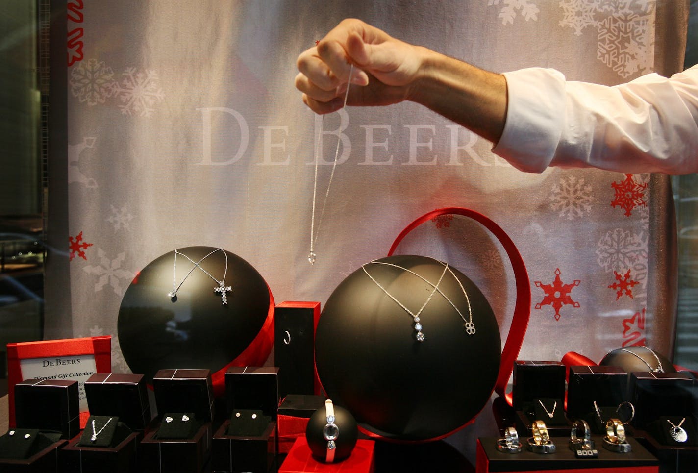 A store employee places jewelry in a window display at De Beers on New York's Fifth Ave. Monday, Nov. 24, 2008. Wealthy Americans _ faced with the sharpest decline in net worth in more than 50 years _ are slashing their spending at a rate unseen in decades, while re-evaluating their priorities. (AP Photo/Mark Lennihan) ORG XMIT: NYML206