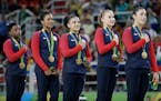 U.S. gymnasts and gold medallists, left to right, Simone Biles, Gabrielle Douglas, Lauren Hernandez, Madison Kocian and Aly Raisman stand for their na