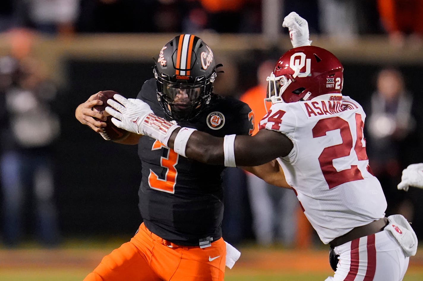 Oklahoma linebacker Brian Asamoah (24) tackles Oklahoma State quarterback Spencer Sanders (3) during an NCAA college football game against Oklahoma, Saturday, Nov. 27, 2021, in Stillwater, Okla. (AP Photo/Sue Ogrocki)