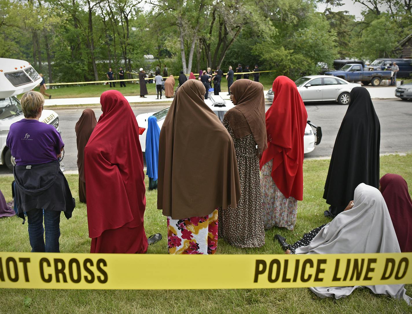 Community members wait for news during the search for missing 6-year-old Hamza Elmi Friday, July 24, 2015, on the banks of the Mississippi River in St. Cloud, Minn. The boy's body was later found in the river. (Dave Schwarz /St. Cloud Times via AP) NO SALES; MANDATORY CREDIT ORG XMIT: MIN2015072414293650