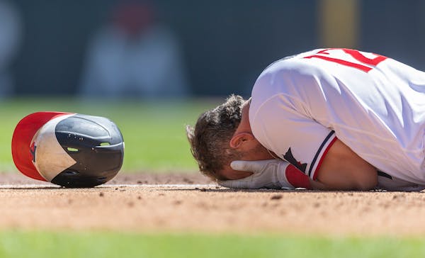 Minnesota Twins third baseman Kyle Farmer (12) falls to the ground after getting hit with a pitch during the bottom of the fourth inning.