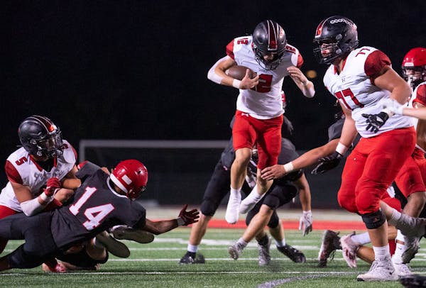 Shakopee quarterback Leyton Kerns (12) leaped over Eden Prairie defenders as he scrambled in the first half. ]