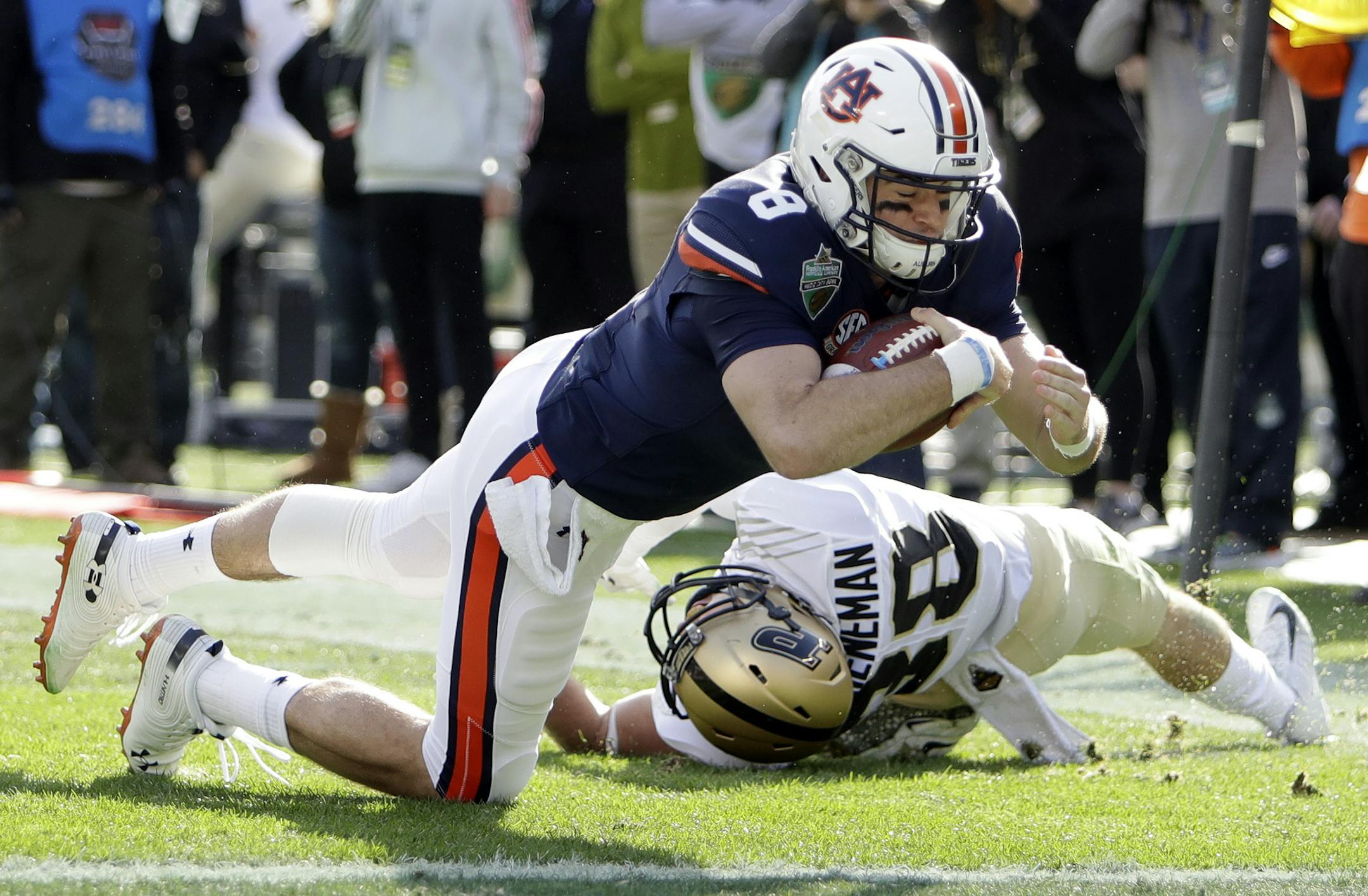 Auburn quarterback Jarrett Stidham (8) drives past Purdue safety Brennan Thieneman (38) and into the end zone in the first half of the Music City Bowl NCAA college football game Friday, Dec. 28, 2018, in Nashville, Tenn. Stidham was ruled down at the 1-yard line. (AP Photo/Mark Humphrey)