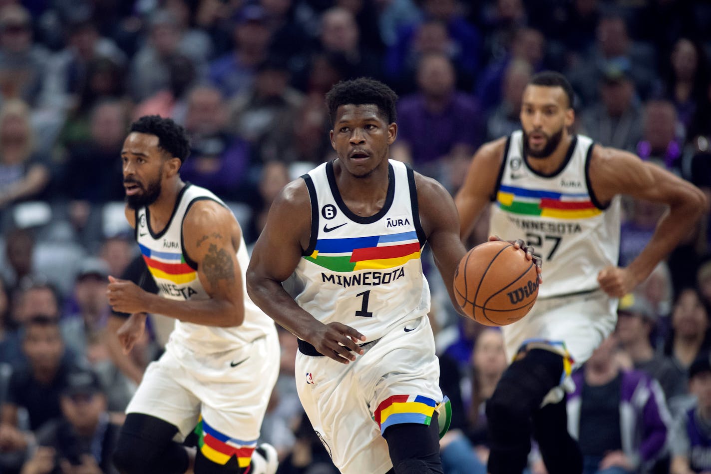 Minnesota Timberwolves guard Anthony Edwards (1) starts a fast break, trailed by teammates, guard Mike Conley (10) and center Rudy Gobert (27) in the first quarter of an NBA basketball game against the Sacramento Kings in Sacramento, Calif., Monday, March 27, 2023. (AP Photo/José Luis Villegas)