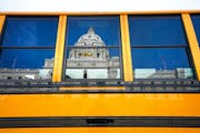 This file photo shows a school bus outside the Minnesota State Capitol in February 2020. More than 50 school board members in Minnesota have left thei