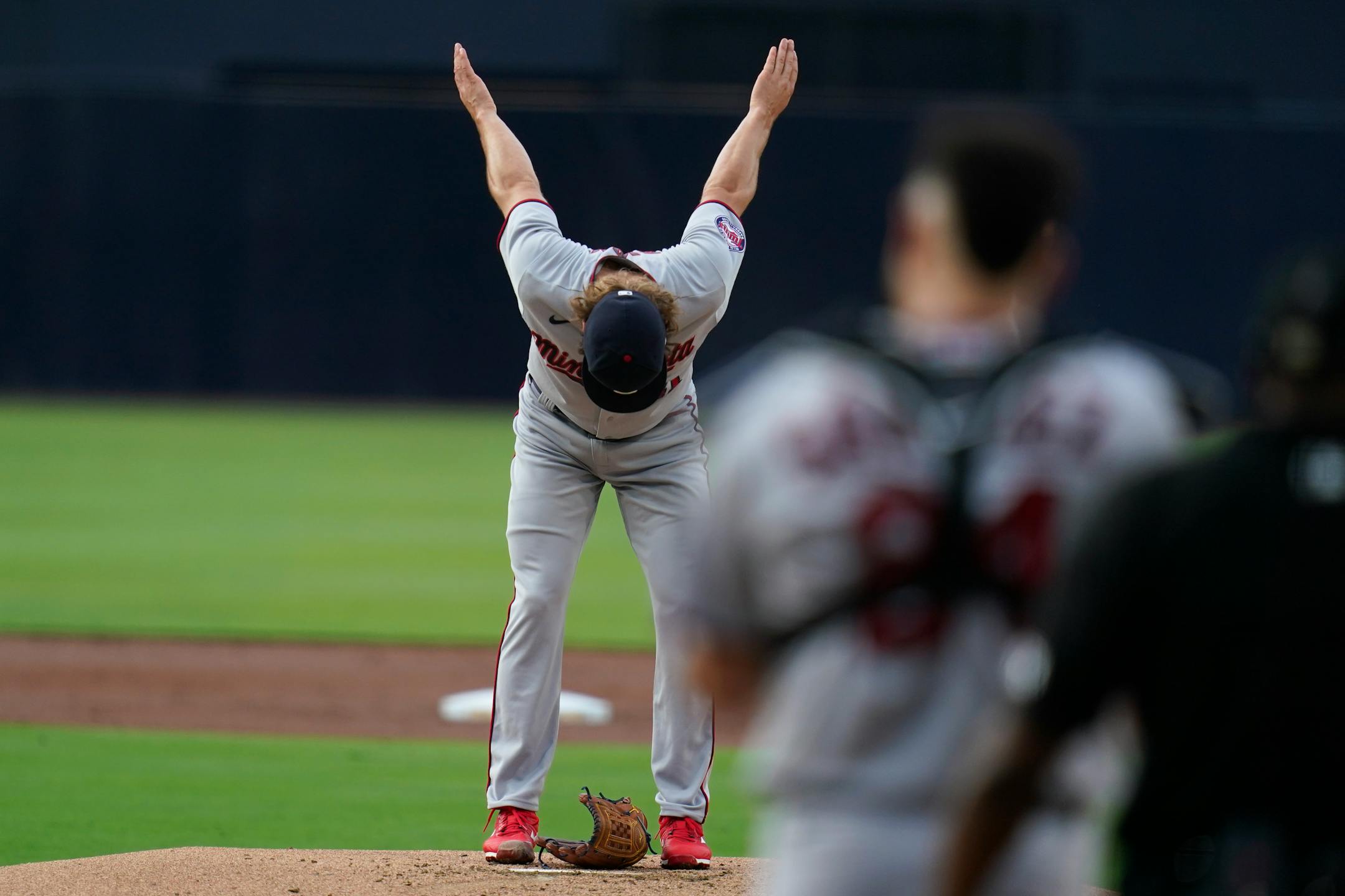 Minnesota Twins starting pitcher Joe Ryan stretches before facing his first San Diego Padres batter to start the first inning of a baseball game Friday, July 29, 2022, in San Diego. (AP Photo/Gregory Bull)