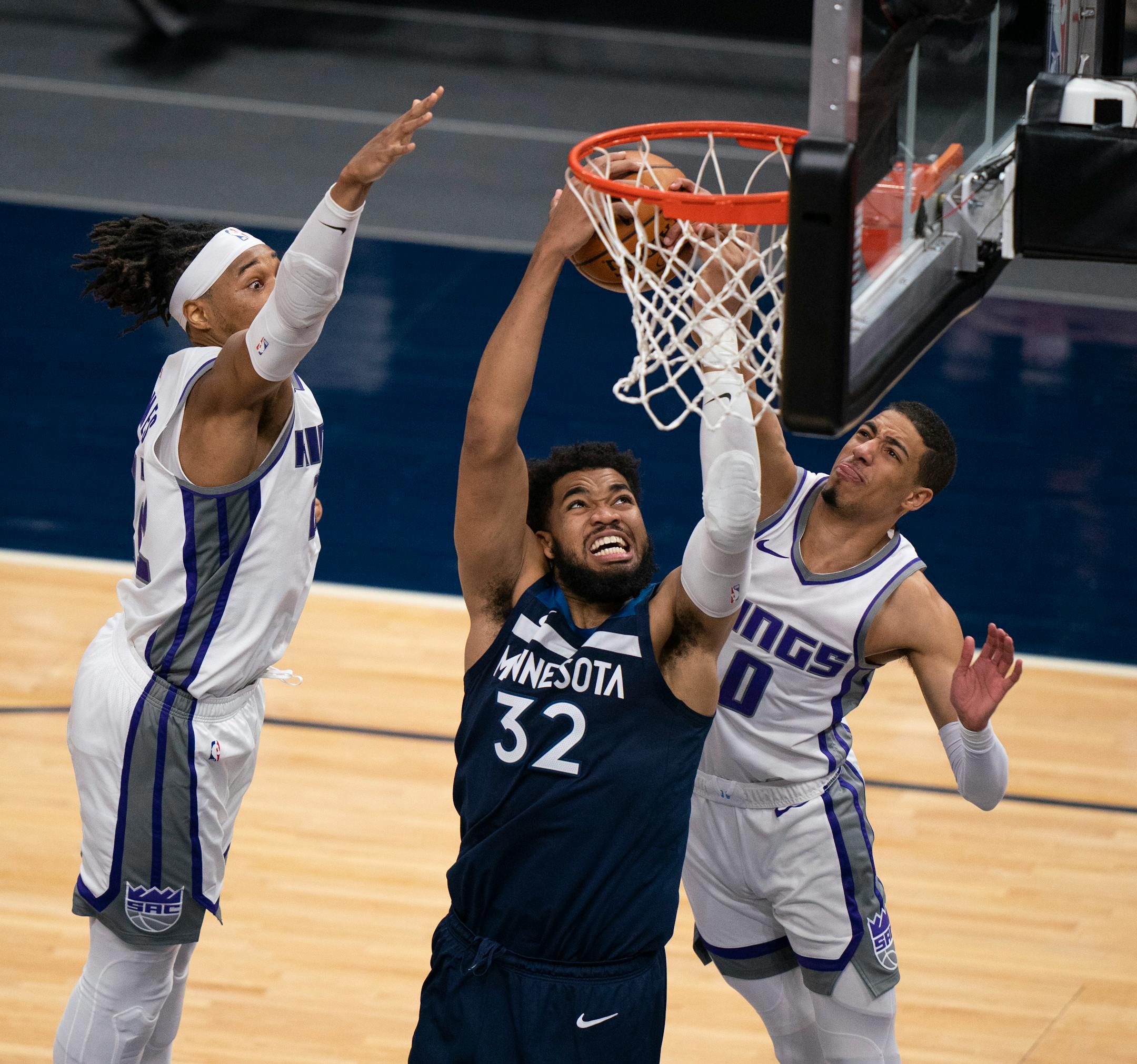 Minnesota Timberwolves center Karl-Anthony Towns (32) was fouled by Sacramento Kings guard Tyrese Haliburton (0) in the third quarter.Sacramento Kings center Richaun Holmes (22) was at left.