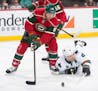 Minnesota Wild center Ryan Carter (18) chases down the puck as San Jose Sharks center Joe Pavelski (8) falls to the ice during the first period. ] (Aa