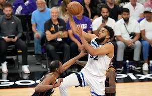 Wolves center Karl-Anthony Towns, right, drives to the basket against the Kevin Durant during the first half Sunday night in Phoenix.