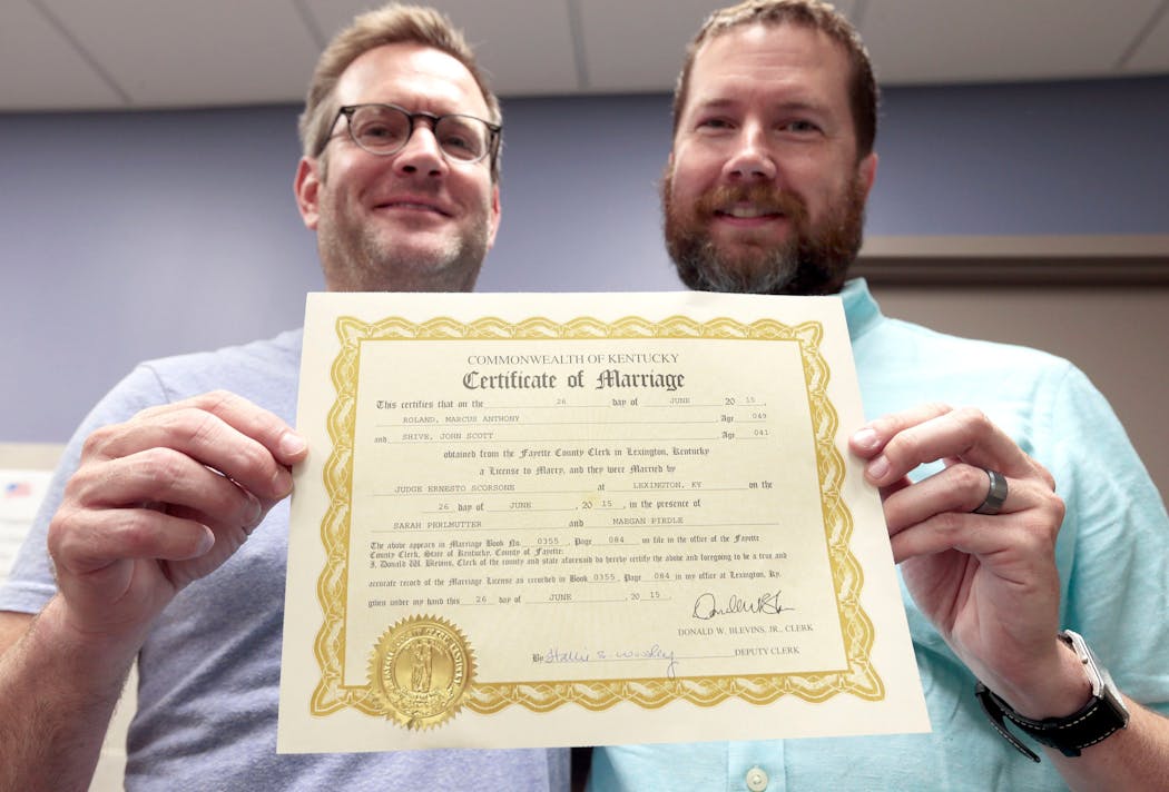 Marc Roland, left, and Scott Shive held their marriage license after their historic union in Lexington, Ky., on June 26, 2015. They were the first gay couple to get married in their county after the U.S. Supreme Court required all states to grant same-sex marriage.